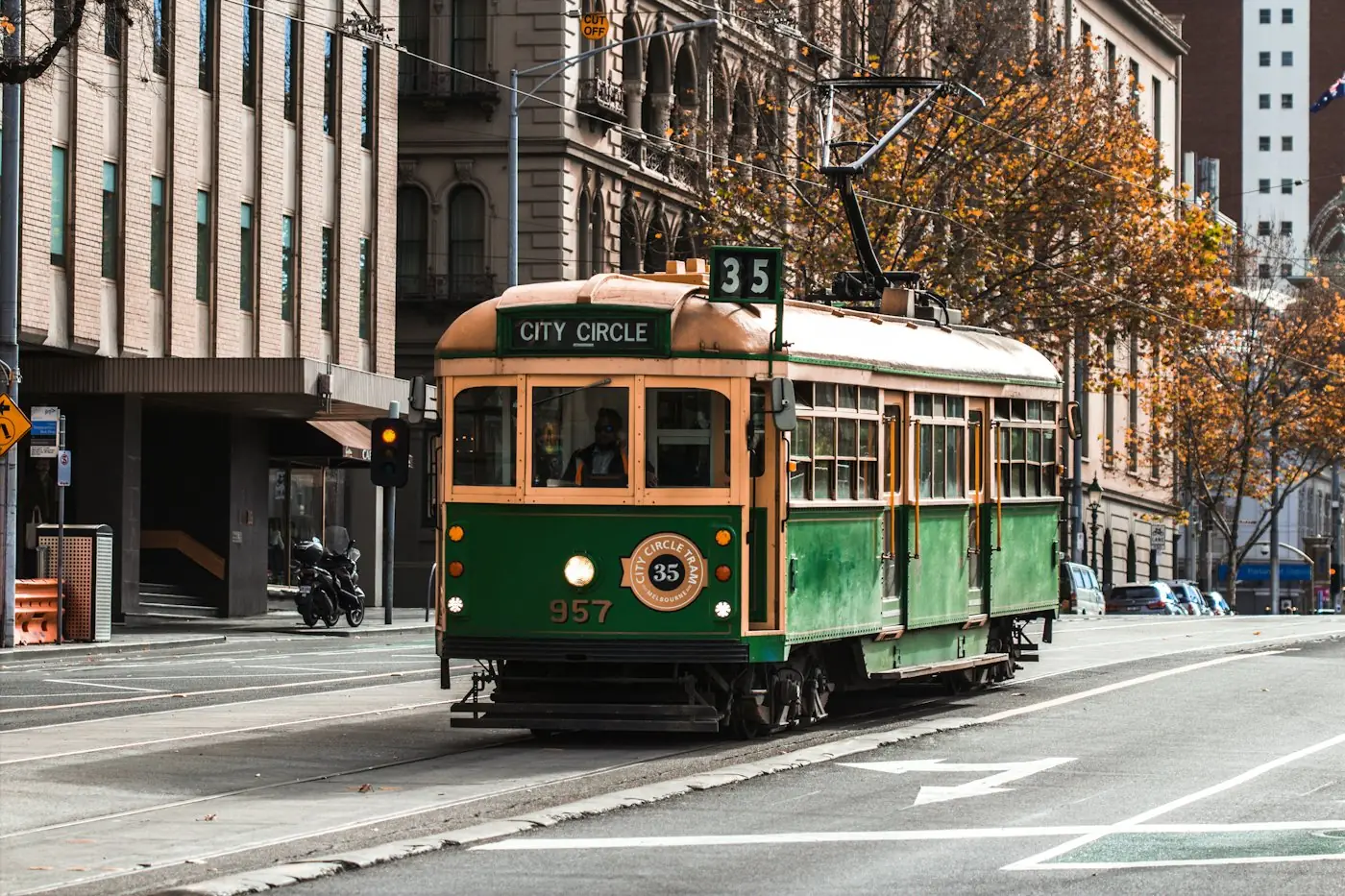 Green Melbourne tram travelling along a city street